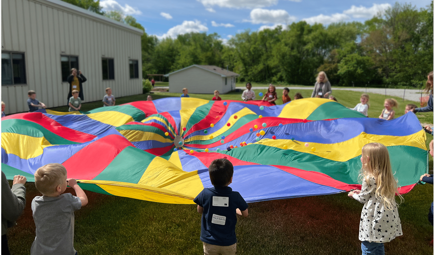 children playing with large parachute
